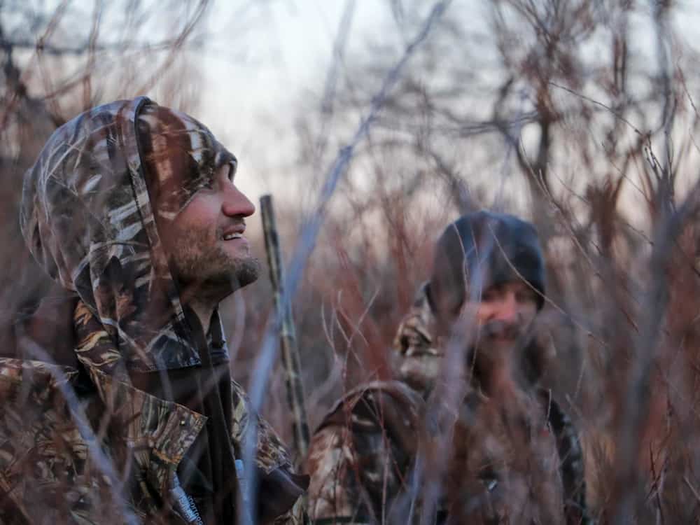 Three hunters in a wooded area