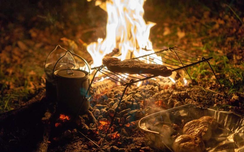 Meat cooking over a campfire