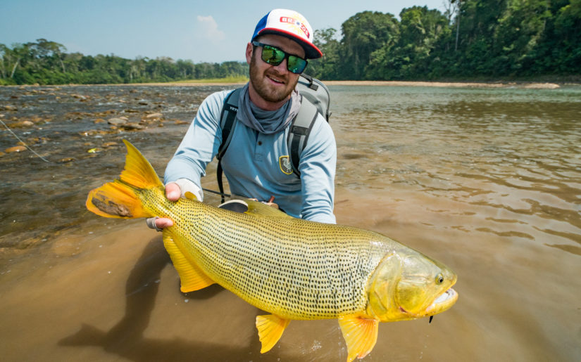 Campfire Collective Fishing Ambassador Christiaan Pretorius holding a Golden Dorado on a fishing trip Bolivia.