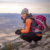 Campfire Collective Ambassador Leah Tyler-Szucki sitting on the side of a mountain after hiking to the top.