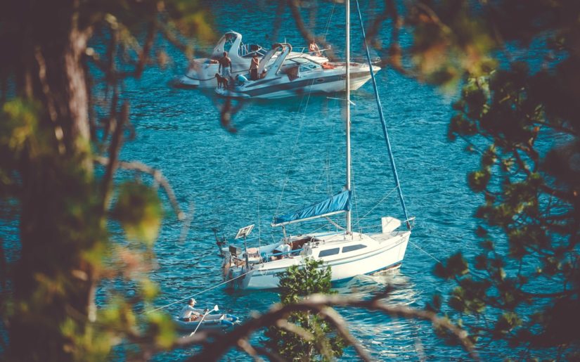 Sailboat and powerboats anchored on a sandbar.