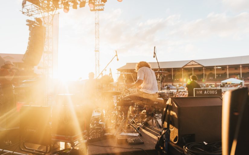 Backstage view of a band playing at a summertime concert.