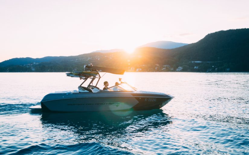 Two younger boaters driving a Ski Nautique wakeboarding boat.