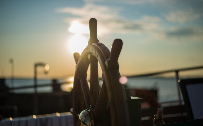 Close-up of ship steering wheel on the bridge of a boat.