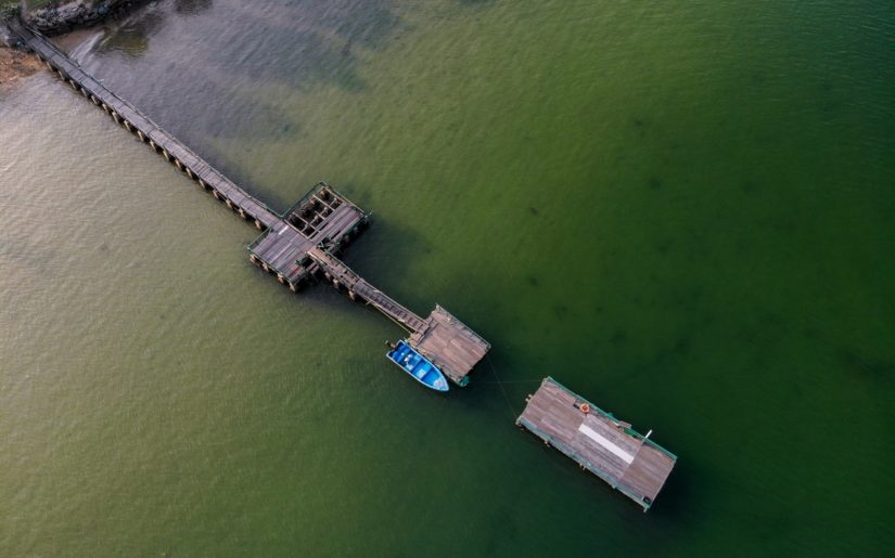 Aerial view of small motorboat properly tied to a dock.